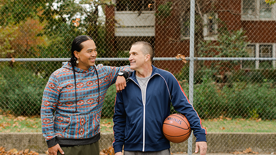 Two older men who were playing basketball and looking at each other