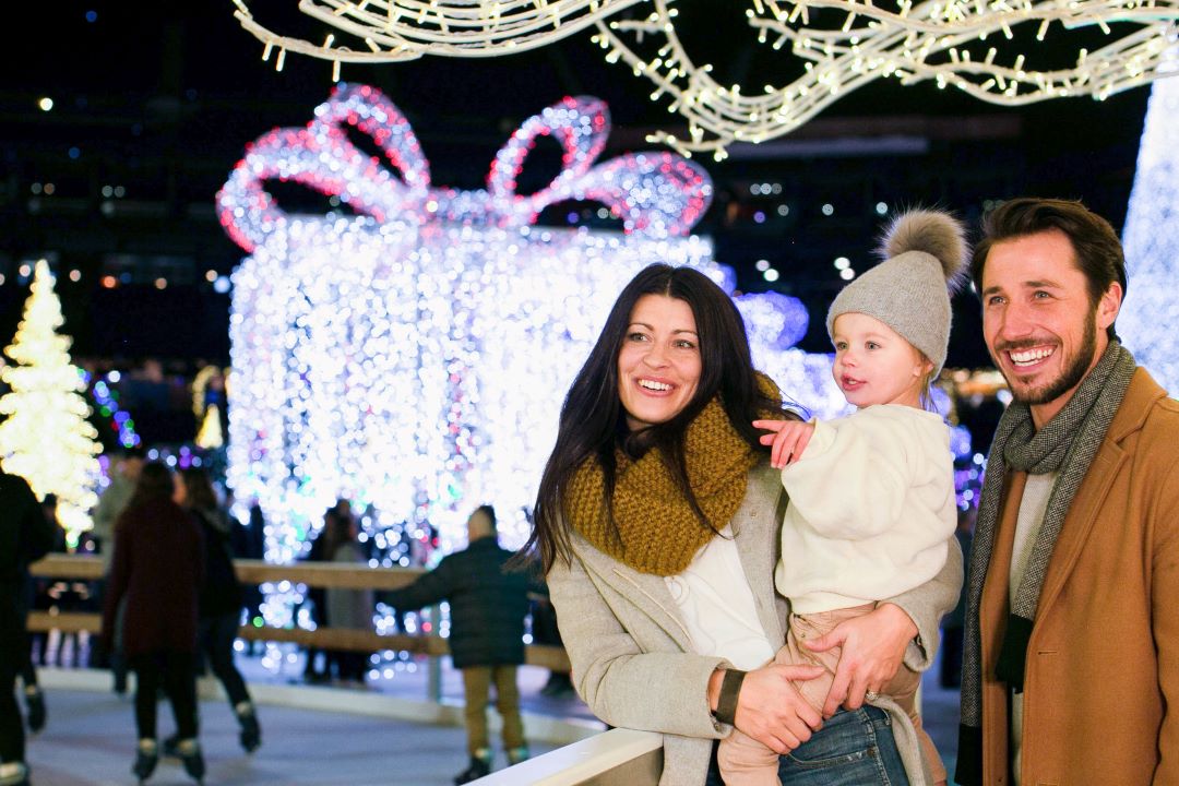 A mom, dad and child smiling and looking at lights