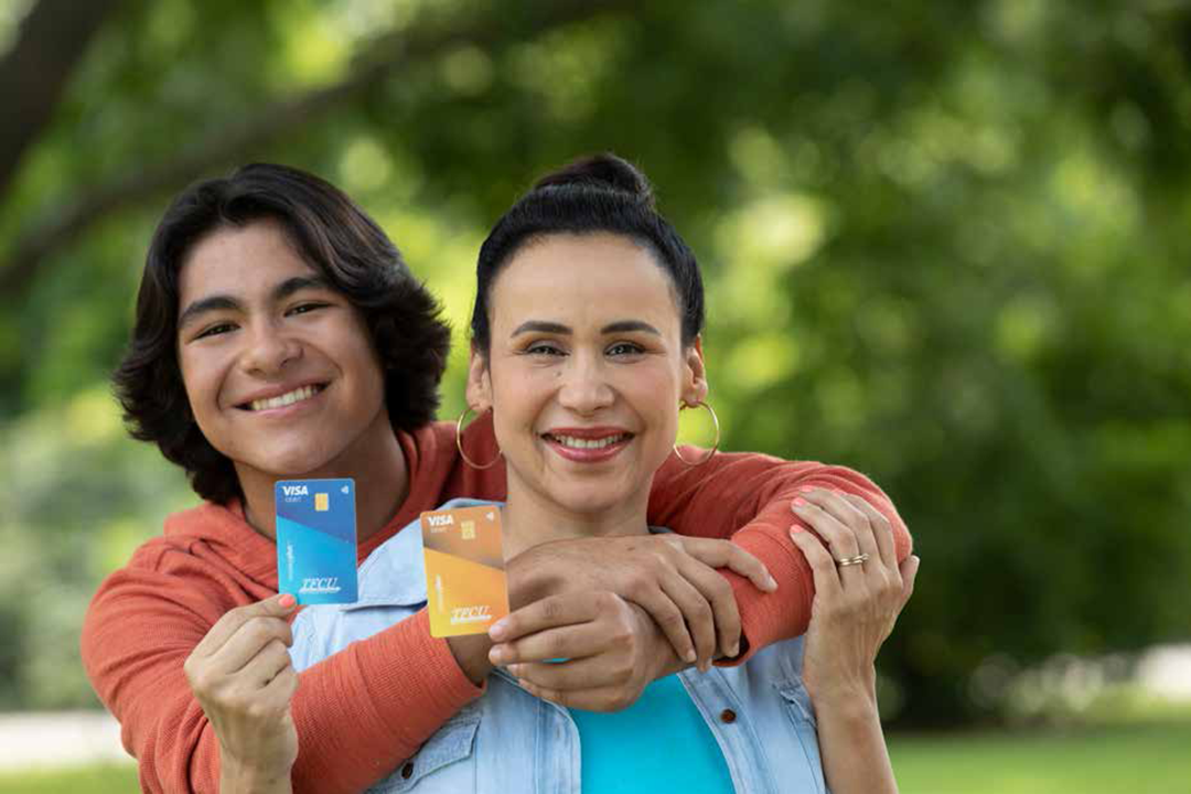 A son hugging his mom and both are holding a teal and yellow MoneyPlus card.