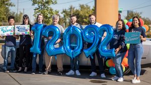 Employees holding number balloons