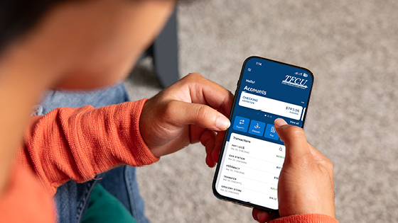 Close up of someone using their TFCU mobile banking on their smartphone