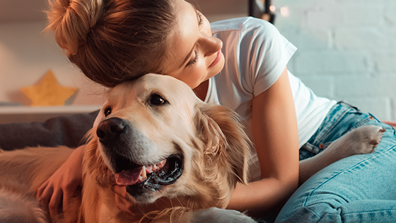 A young woman hugging her dog.