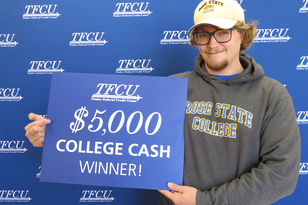 A student holding up a sign that says $5,000 college cash winner