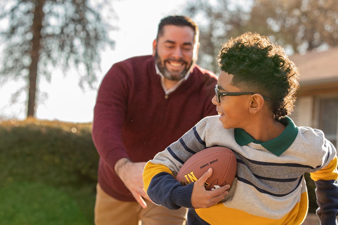 Father playing football with his son