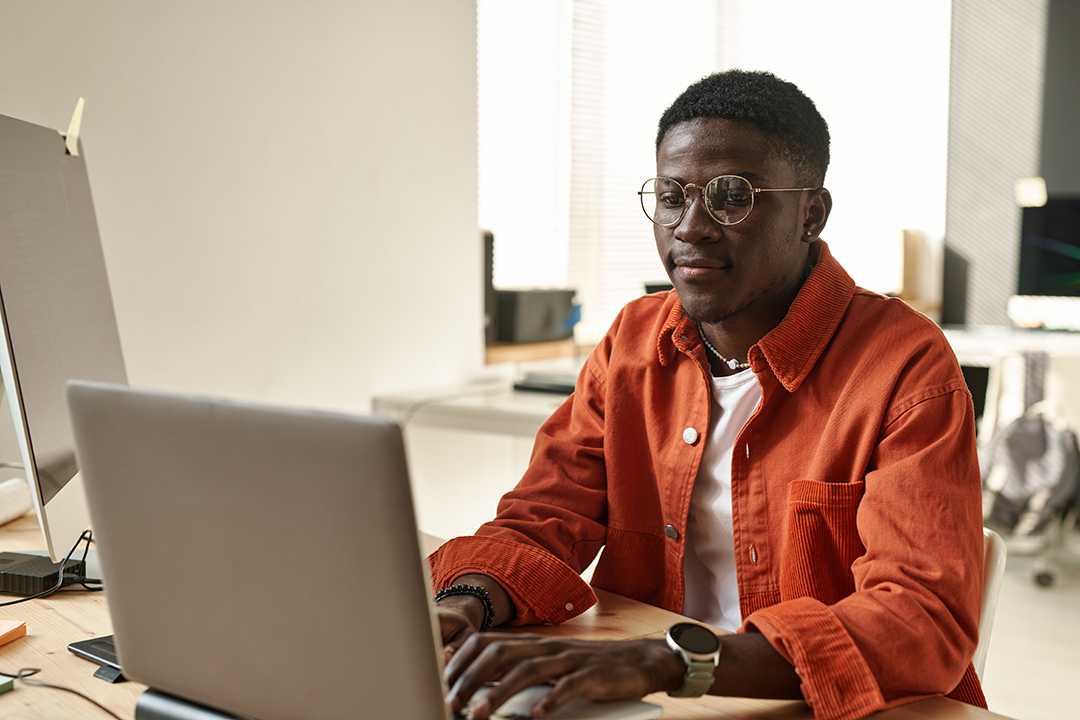 A man is typing on a laptop